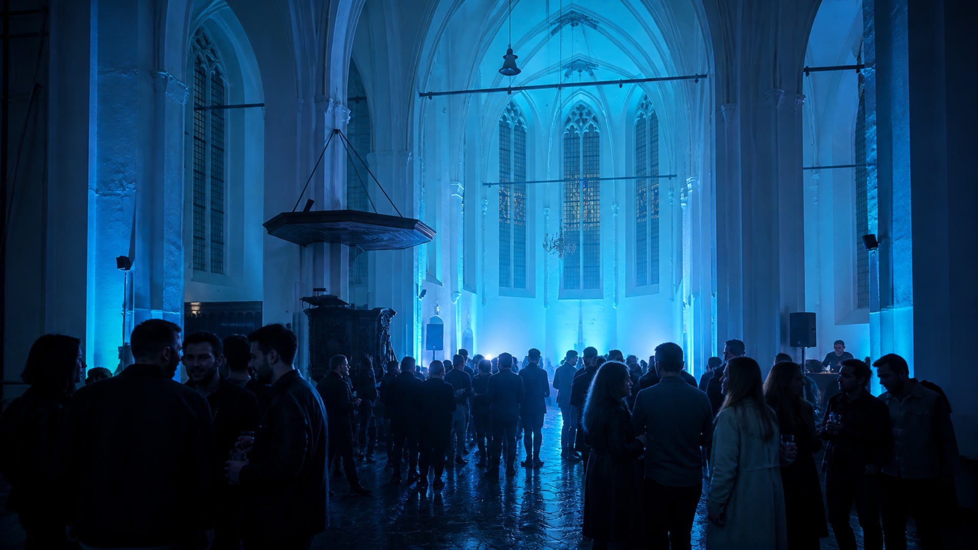 The first thaw: cyan light building in the volume of the nave above a dense crowd.
